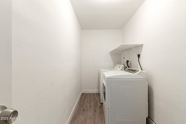 laundry area featuring washer and dryer and light hardwood / wood-style flooring