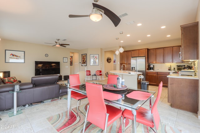 dining area with light tile flooring, ceiling fan, and sink