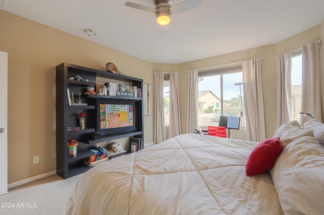 bedroom with ceiling fan, light colored carpet, and multiple windows