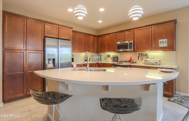 kitchen featuring hanging light fixtures, stainless steel appliances, and a breakfast bar area