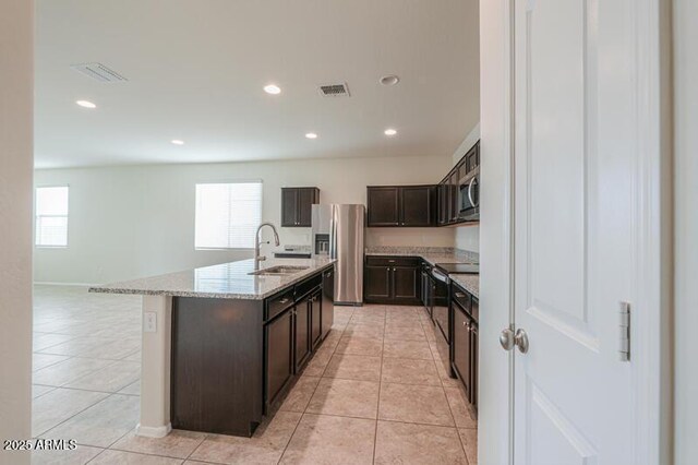 1127 E Tyler Ln, Casa Grande, AZ 85122 - kitchen with visible vents, dark brown cabinets, light stone countertops, a sink, and appliances with stainless steel finishes