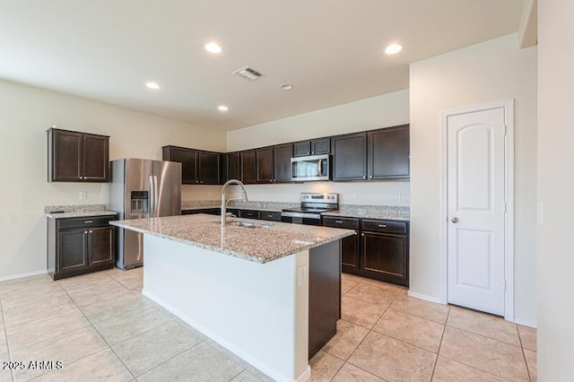 1127 E Tyler Ln, Casa Grande, AZ 85122 - kitchen with visible vents, appliances with stainless steel finishes, a sink, light tile patterned floors, and light stone counters