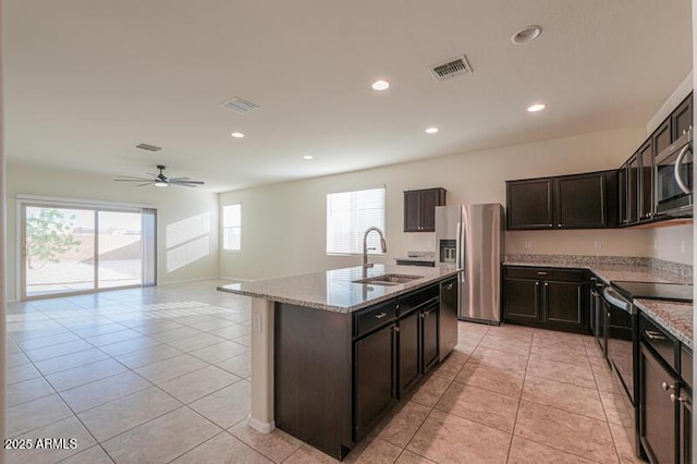 1127 E Tyler Ln, Casa Grande, AZ 85122 - kitchen with visible vents, appliances with stainless steel finishes, a sink, light stone counters, and an island with sink