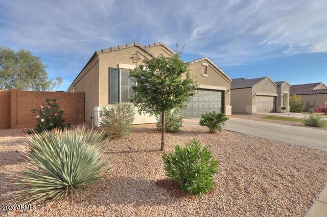 1127 E Tyler Ln, Casa Grande, AZ 85122 - view of front of house with a garage, fence, stucco siding, and driveway