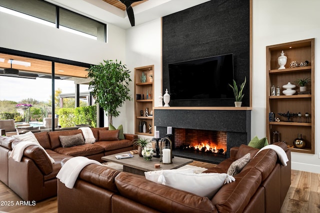 8328 E Whisper Rock Trl, Scottsdale, AZ 85266 - living area featuring a towering ceiling, a large fireplace, built in features, and wood finished floors