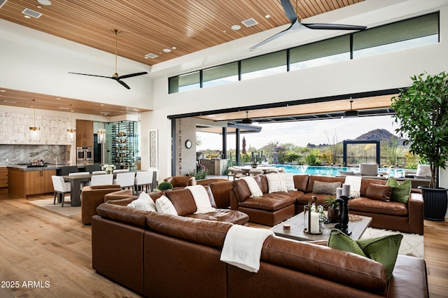8328 E Whisper Rock Trl, Scottsdale, AZ 85266 - living room with wooden ceiling, recessed lighting, light wood-style flooring, ceiling fan, and a towering ceiling
