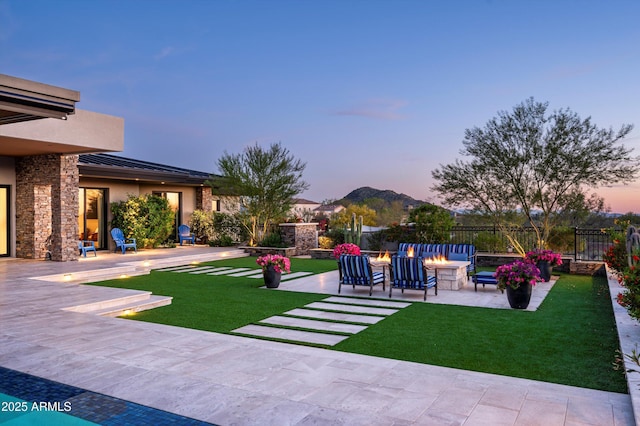 8328 E Whisper Rock Trl, Scottsdale, AZ 85266 - yard at dusk with fence, an outdoor fire pit, a patio, and a mountain view