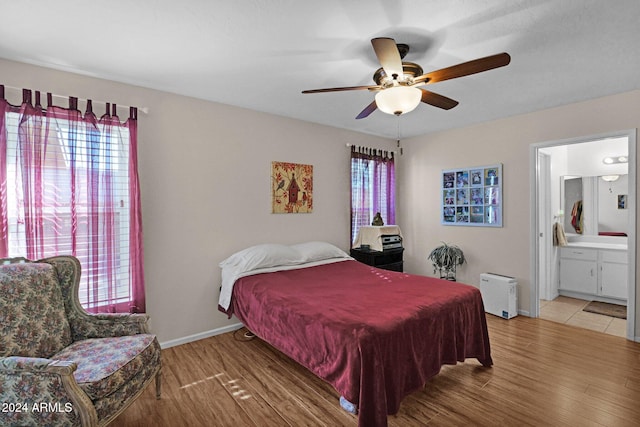 bedroom featuring ensuite bath, ceiling fan, and wood-type flooring