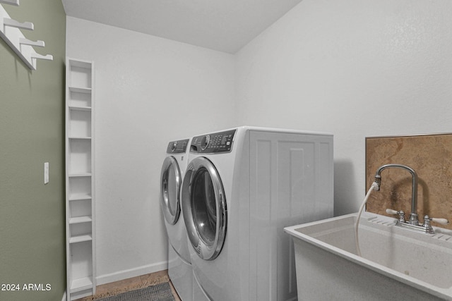 clothes washing area featuring separate washer and dryer and sink