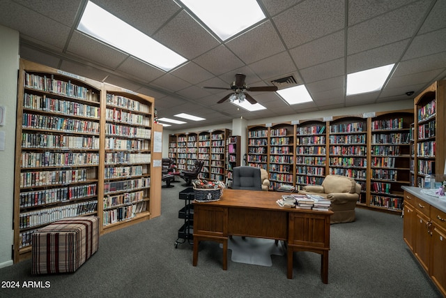 office area featuring a paneled ceiling, ceiling fan, and carpet