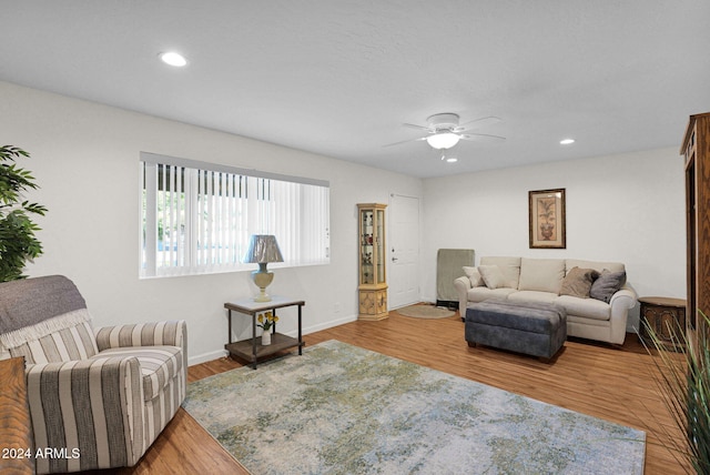 living room featuring wood-type flooring and ceiling fan