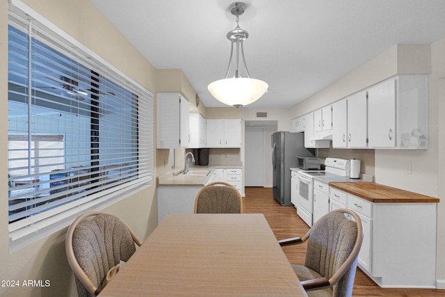 kitchen featuring pendant lighting, white cabinetry, wood-type flooring, and white electric range