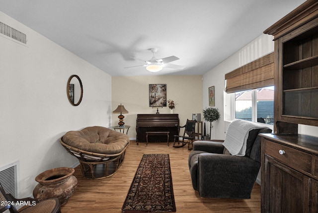 living area with light hardwood / wood-style floors and ceiling fan