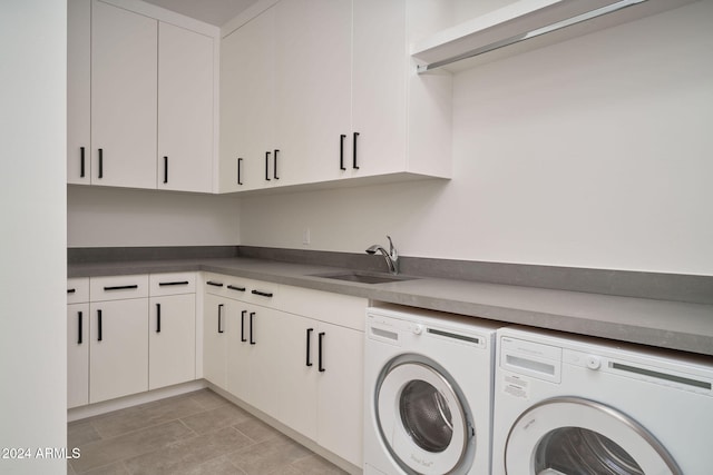 washroom with sink, cabinets, and independent washer and dryer