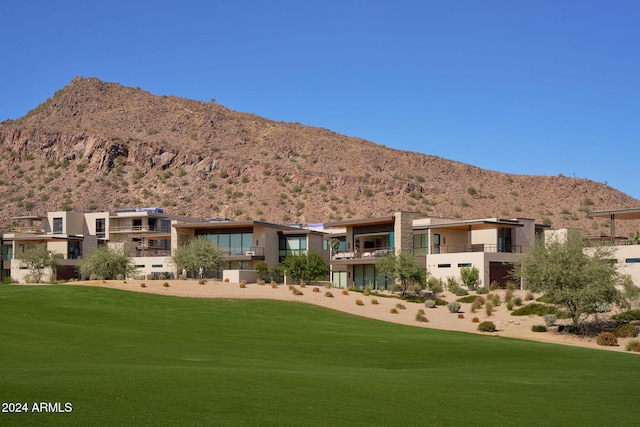 view of home's community with a mountain view and a yard