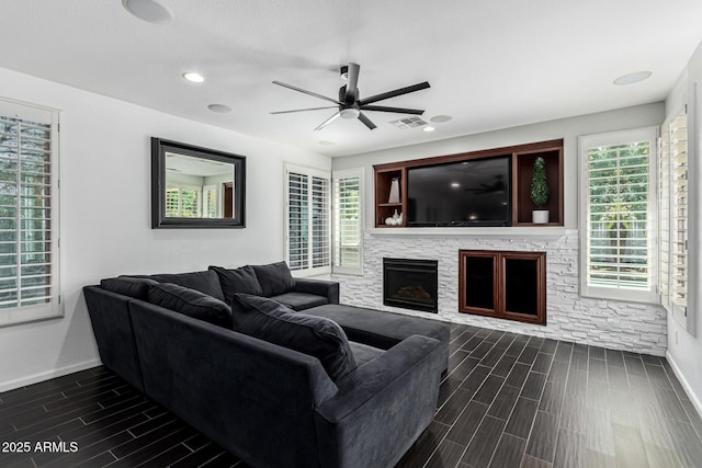 living room featuring a fireplace and ceiling fan