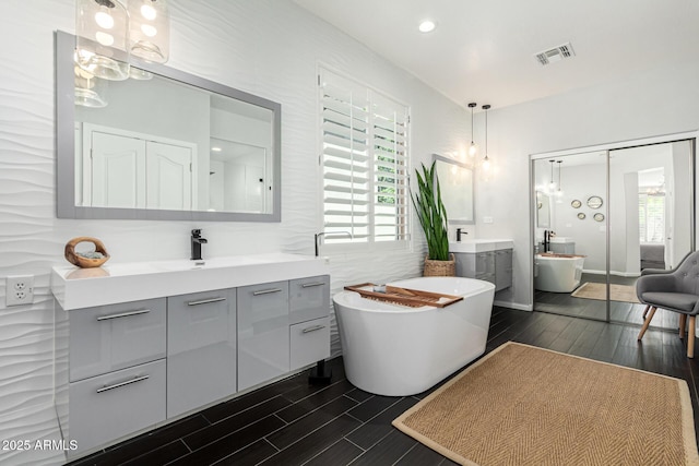 bathroom featuring a tub, vanity, and wood-type flooring