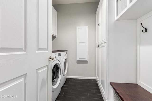 clothes washing area with washer and clothes dryer and cabinets