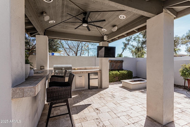 view of patio / terrace featuring grilling area, a gazebo, an outdoor fire pit, an outdoor kitchen, and ceiling fan