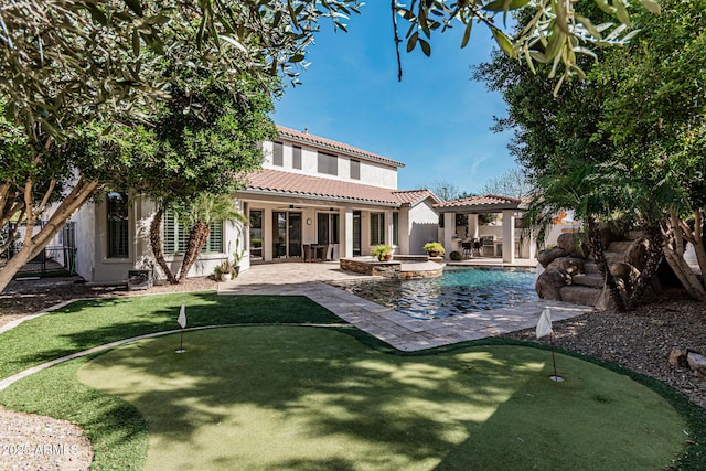 rear view of house with a pool with hot tub, a patio, and a gazebo