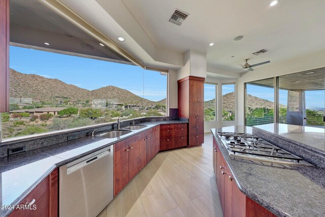 unfurnished living room featuring an inviting chandelier, a raised ceiling, light wood-type flooring, and a mountain view