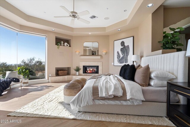 unfurnished dining area with a mountain view, a notable chandelier, light wood-type flooring, and a tray ceiling