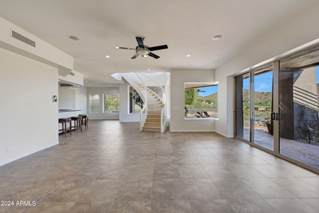 unfurnished living room with ceiling fan and light tile patterned floors