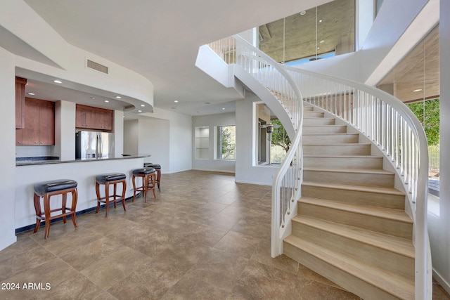 staircase featuring a towering ceiling