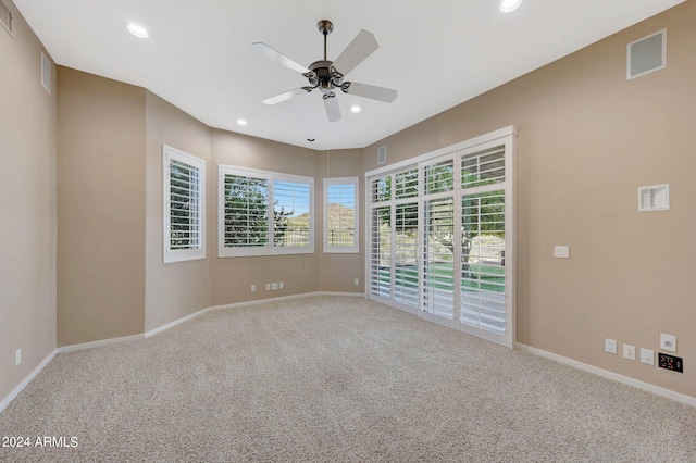 carpeted spare room featuring ceiling fan