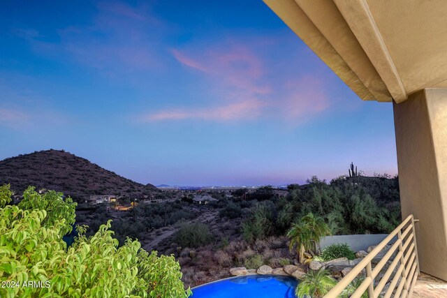 pool at dusk featuring a mountain view