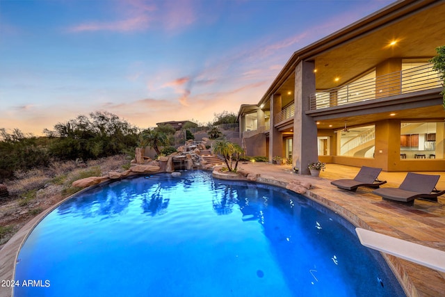 pool at dusk featuring a patio area