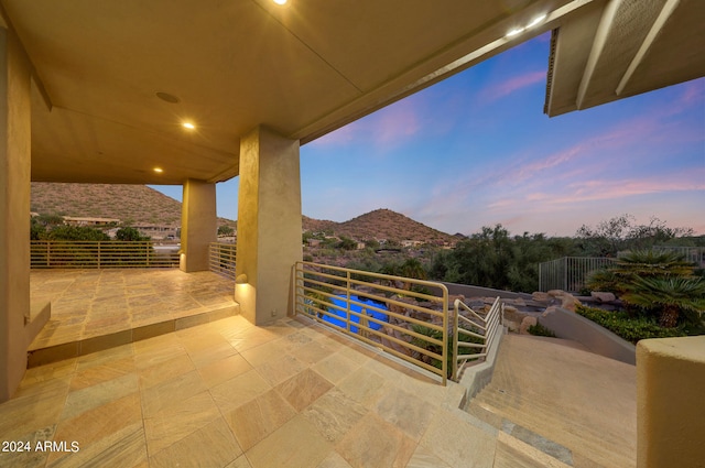 patio terrace at dusk with a balcony and a mountain view