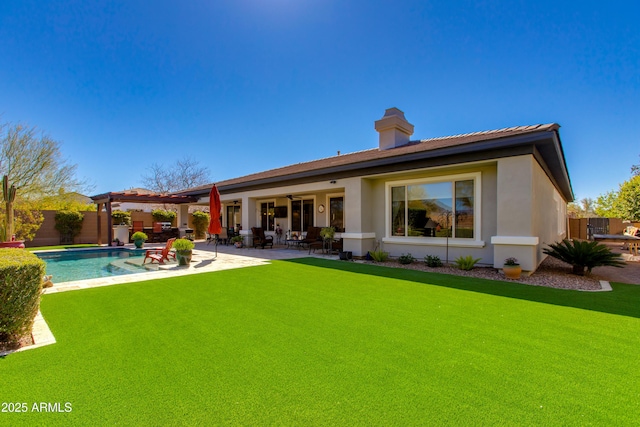 back of house featuring a fenced backyard, a chimney, ceiling fan, a patio, and stucco siding