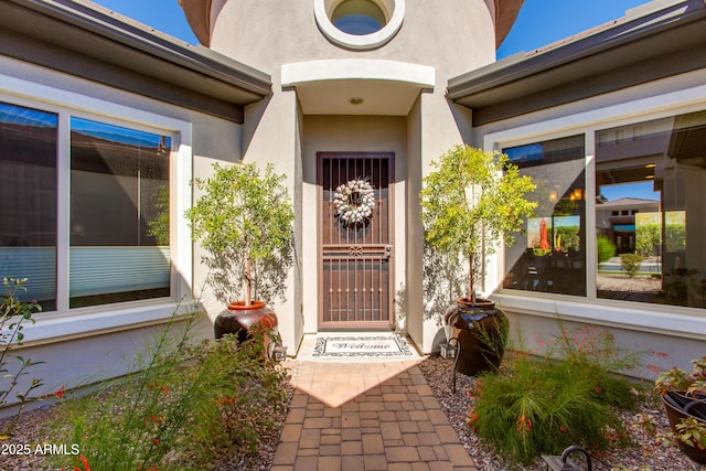 view of exterior entry featuring stucco siding