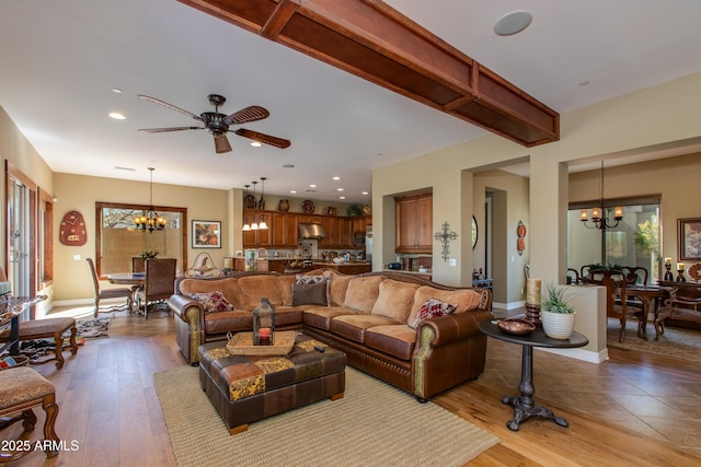 living area featuring recessed lighting, light wood finished floors, baseboards, and ceiling fan with notable chandelier