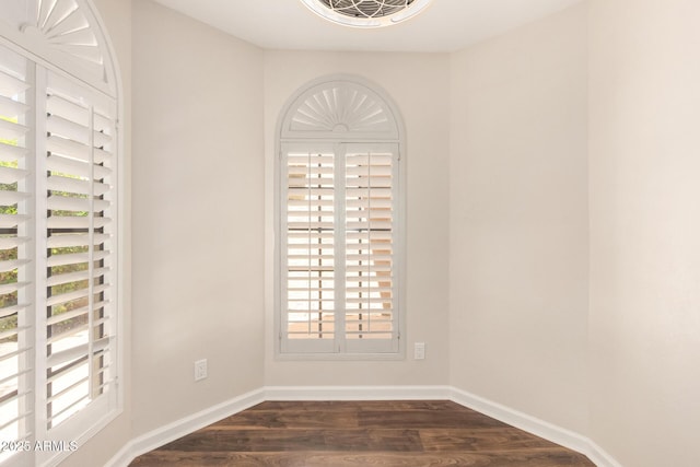 empty room featuring dark wood-style flooring and baseboards