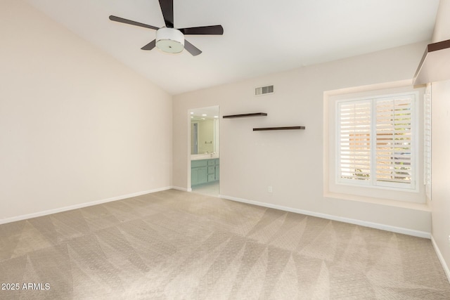 carpeted spare room with baseboards, ceiling fan, vaulted ceiling, and visible vents