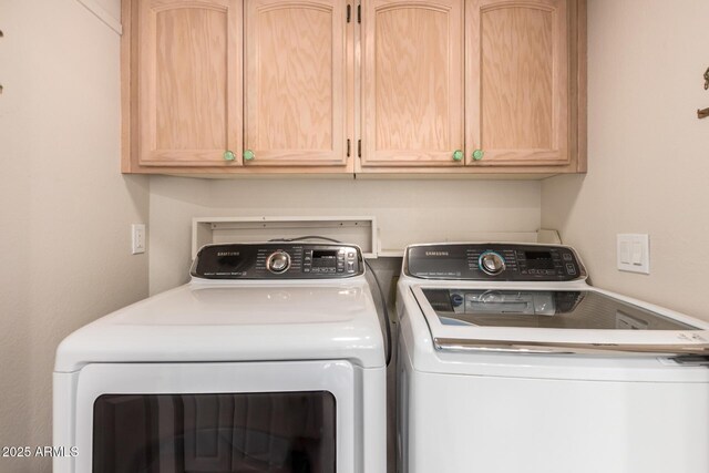 laundry area with washer and clothes dryer and cabinet space