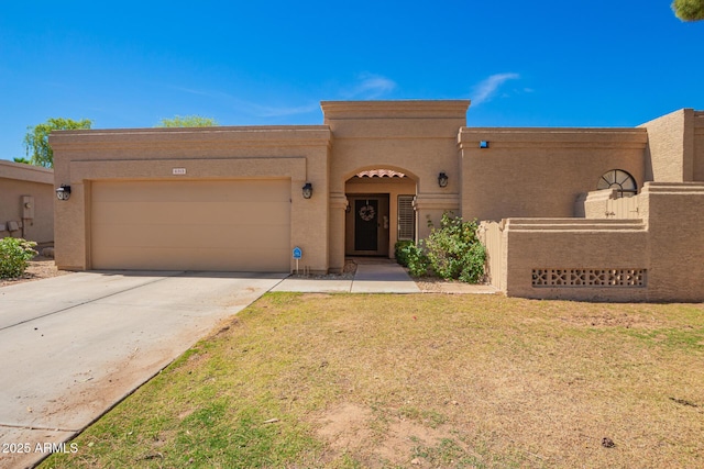 southwest-style home featuring a garage, stucco siding, and driveway