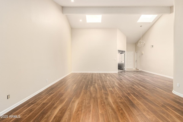 unfurnished living room with high vaulted ceiling, a skylight, baseboards, and dark wood-type flooring