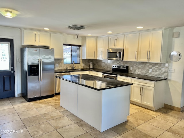 4213 N Westview Dr, Phoenix, AZ 85015 - kitchen with stainless steel appliances, a sink, white cabinets, light tile patterned floors, and tasteful backsplash