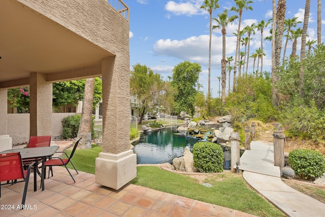 view of patio / terrace with a water view, fence, and outdoor dining area