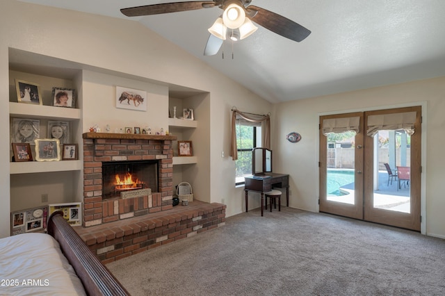 living area with french doors, lofted ceiling, carpet, a ceiling fan, and a brick fireplace
