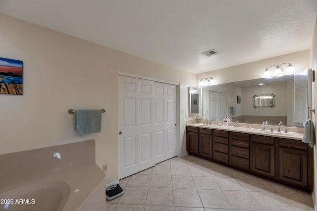 bathroom featuring tile patterned floors, double vanity, and a bathtub