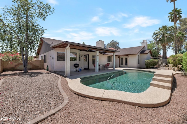 back of house featuring a chimney, french doors, a patio, and stucco siding
