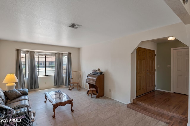 living room with arched walkways and baseboards