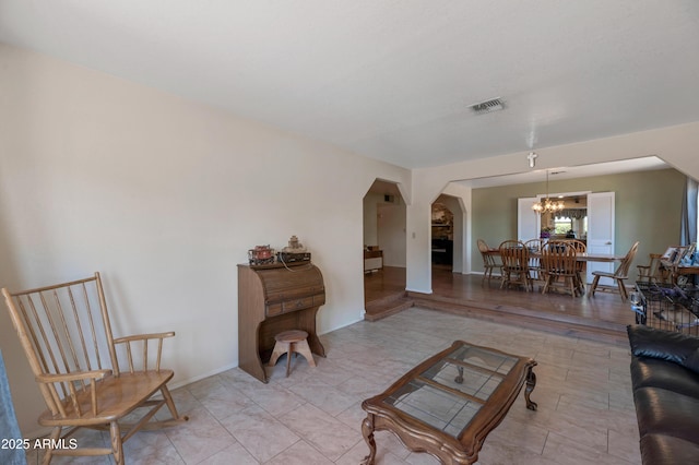 living room with arched walkways and a chandelier