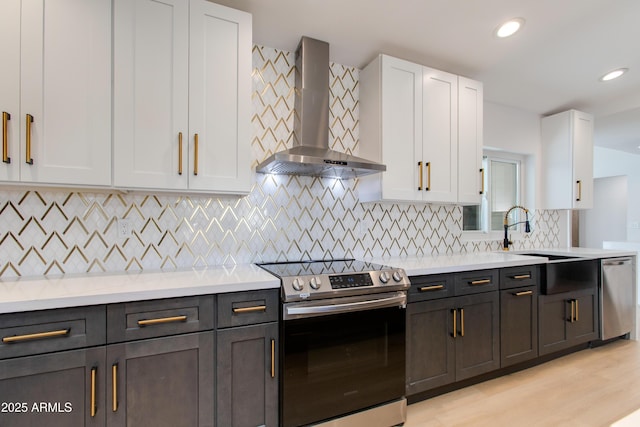 14012 N 57th Pl, Scottsdale, AZ 85254 - kitchen with wall chimney exhaust hood, appliances with stainless steel finishes, white cabinets, light countertops, and recessed lighting
