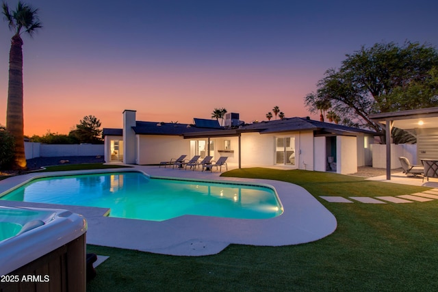 14012 N 57th Pl, Scottsdale, AZ 85254 - back of property at dusk featuring a patio area, solar panels, a fenced backyard, and stucco siding