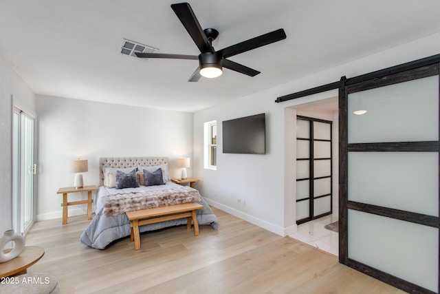 14012 N 57th Pl, Scottsdale, AZ 85254 - bedroom featuring a barn door, light wood-type flooring, and a ceiling fan